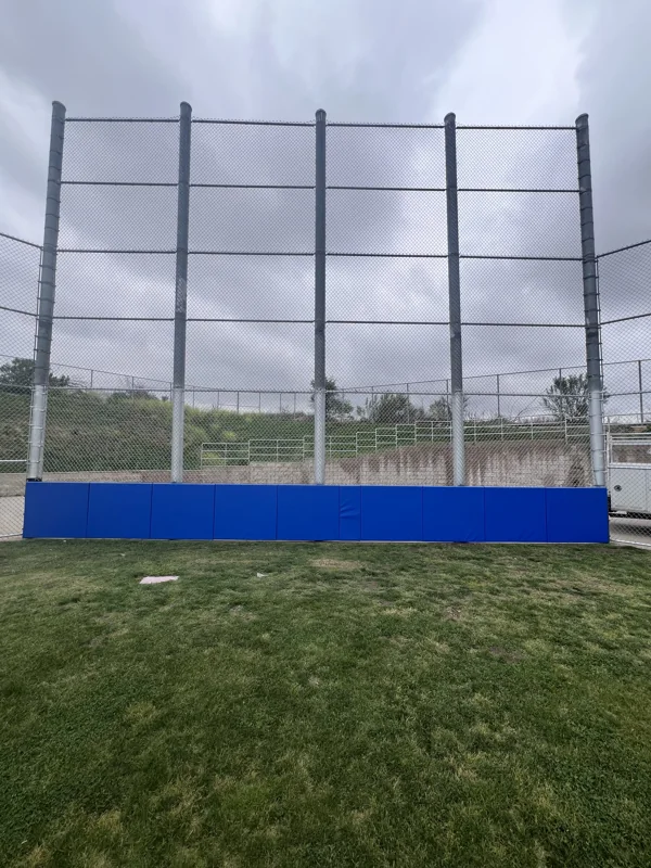 Tall sports backstop with blue padding
